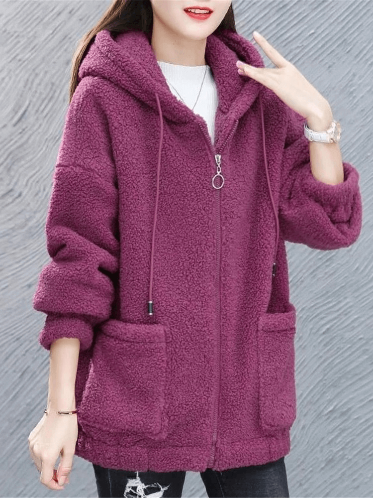 Woman wearing stylish loose fleece jacket with hood, featuring zipper closure and full sleeves in a casual solid pattern.